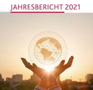 Titelbild des Jahresberichts 2021 des PL, Weltkugel  von Netz umspannt in zwei Händen gehalten gegen Sonnenlicht vor dem Hintergrund einer Stadt